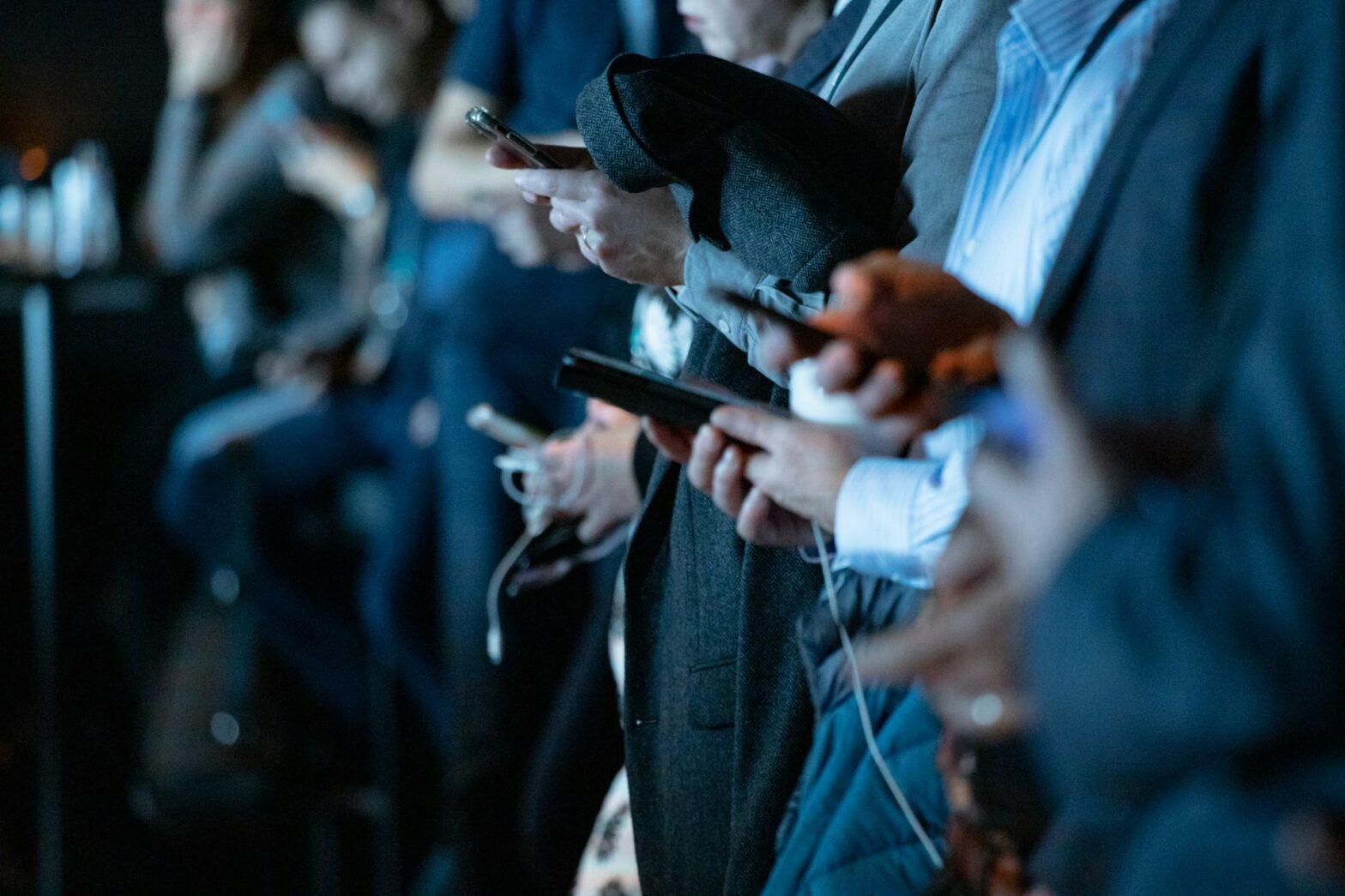 Row of people holding their cell phones.